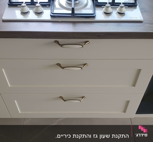 כיריים גז על משטח עץ עם מגירות מתחת